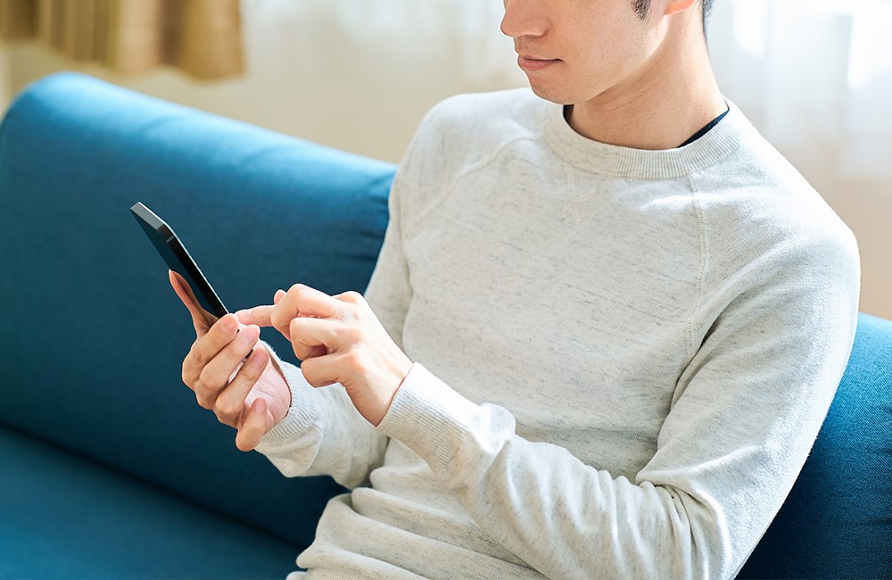 『メンヘラ製造器』からの脱却(落ち着いた様子でスマホを操作する男性)